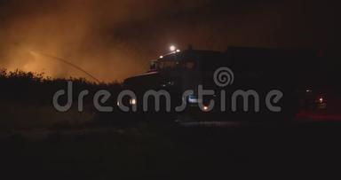 开着闪烁灯的消防车。 森林火灾时在野外焚烧草地背景下的消防车。 救援和救援